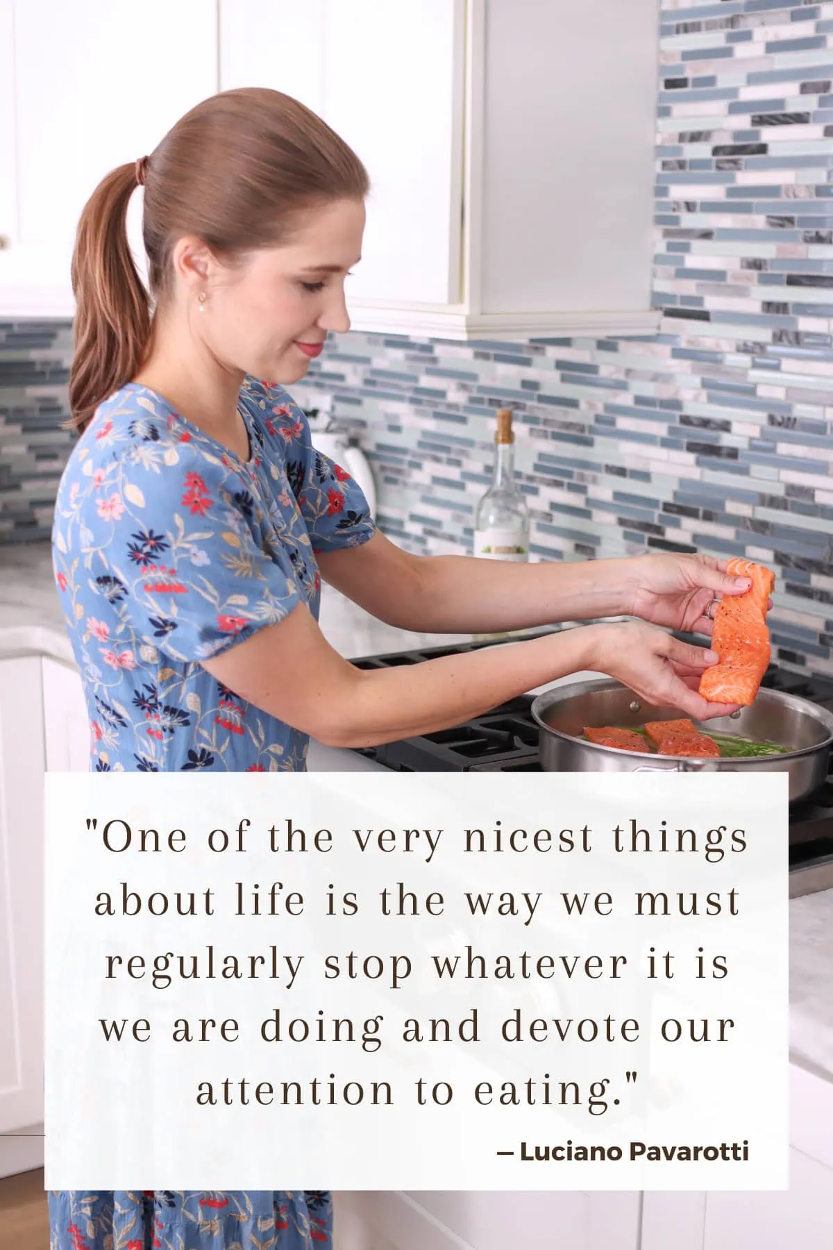 Olga putting salmon into a pan, cooking dinner at the stove. Quote — "One of the very nicest things about life is the way we must regularly stop whatever it is we are doing and devote our attention to eating."