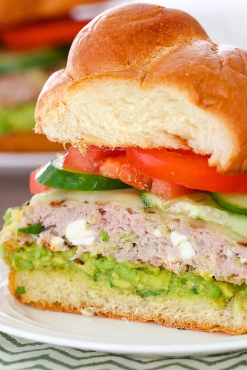 Turkey Zucchini Burgers with feta cheese, cut in half, served with guacamole, tomatoes and cucumbers 