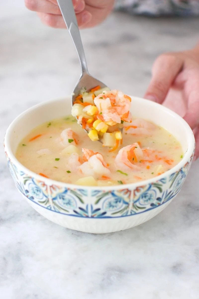 A bowl of creamy shrimp chowder with corn