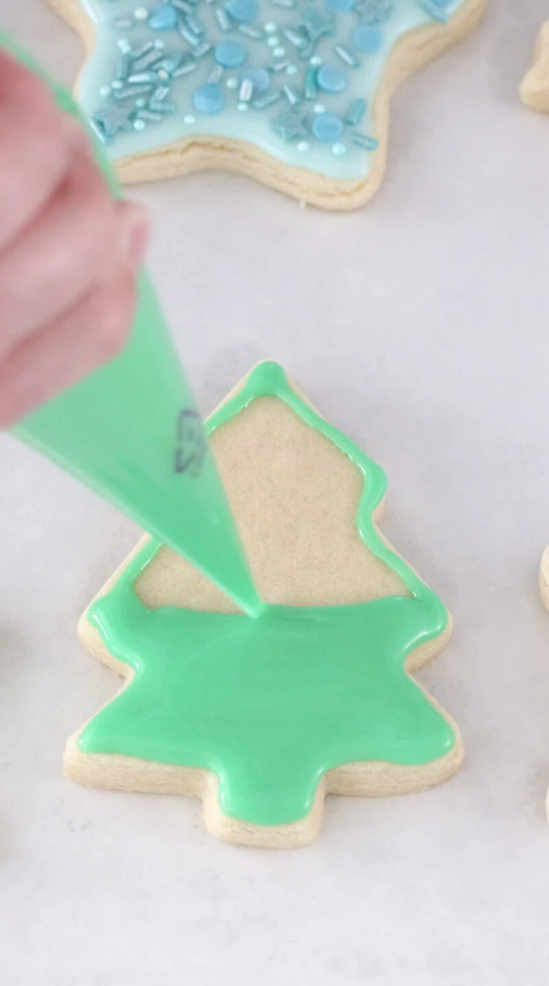 Putting icing on soft cut out sugar cookies