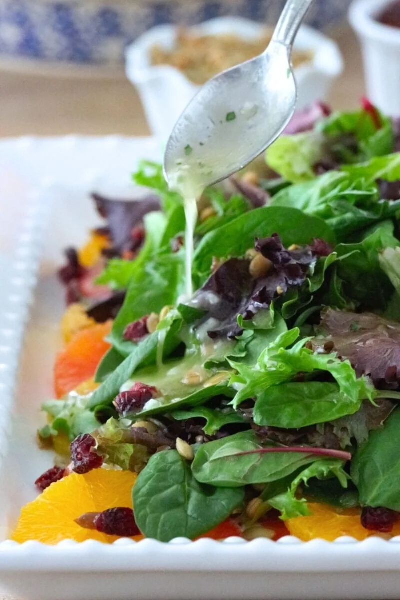 Orange salad made with fresh oranges, spring salad mix, cranberries, pepitas and a fresh orange and lemon vinaigrette