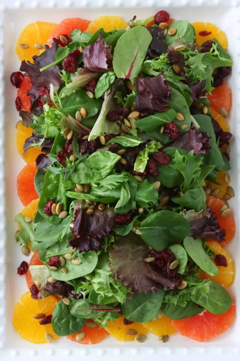 Orange Salad with fresh oranges, spring salad greens, dry cranberries, pepitas and an orange vinaigrette. 