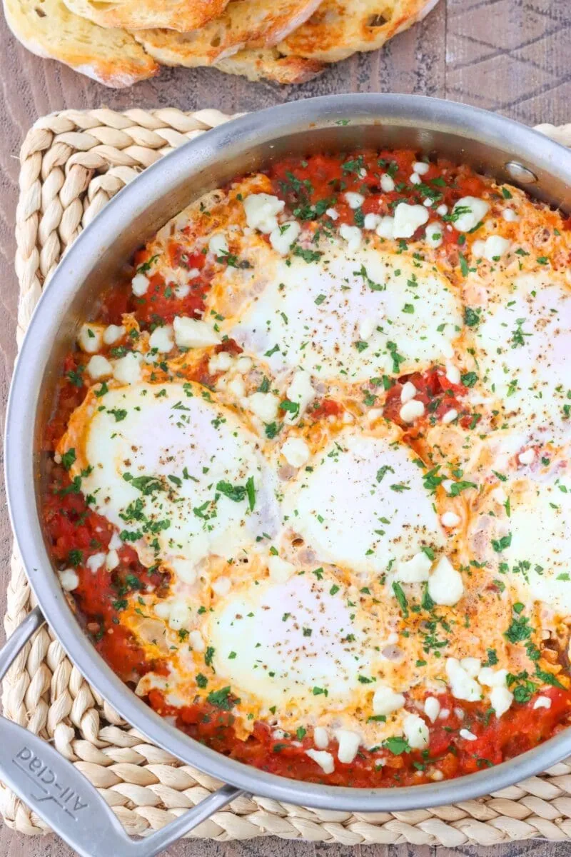 Shakshuka with Fresh Tomatoes, herbs and cotija/feta cheese in a skillet