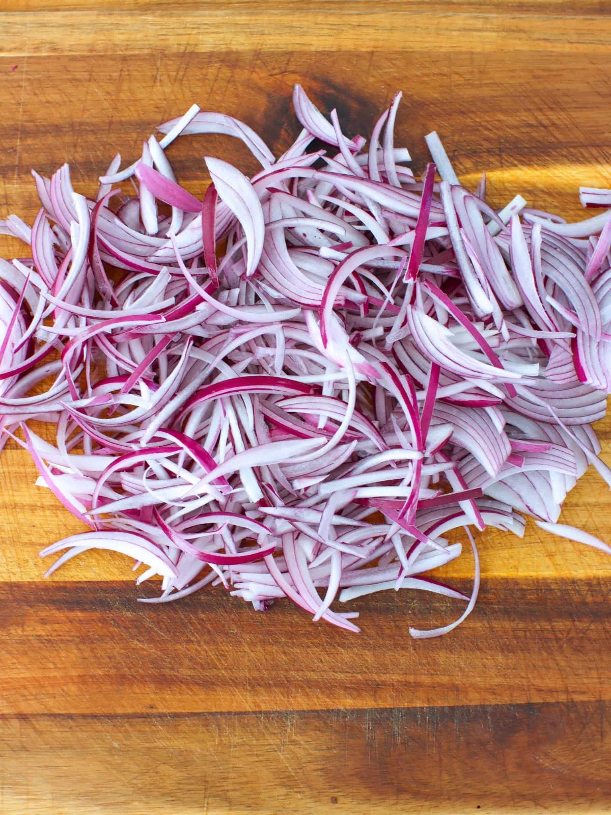 Sliced red onions on a cutting board. 