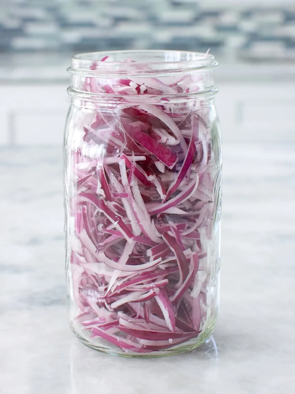 Sliced red onions in a glass mason jars. 